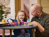 Child and adult playing with LEGO set.