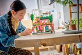 Person building the LEGO Friends restaurant.