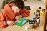 Child following instructions for LEGO Minecraft Ghast Station.