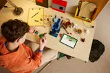 Child building LEGO Minecraft Ghast Station on a desk.