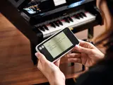 Hands with phone showing LEGO piano song list.