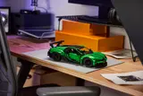 Angled side view of green LEGO Technic Bugatti Chiron on a desk.