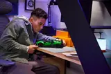 Builder inspecting details of green LEGO Technic Bugatti Chiron.