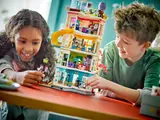 Two children playing with LEGO Friends Community Center.
