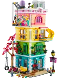 Front view of the colorful LEGO Friends Community Center with minifigures and a slide.