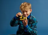 Boy examining LEGO Technic 42163 bulldozer.