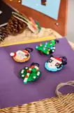Four LEGO ornaments on a purple surface.