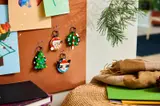 LEGO ornaments hanging on a cork board.