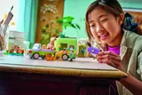 Child playing with the LEGO Friends horse and foal trailer set.