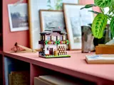 Alpine house on pink shelf.