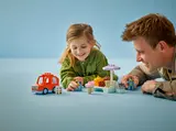 Child and adult playing with LEGO Duplo Bluey set.