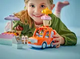 Child stacking ice cream on Bluey's Duplo van.