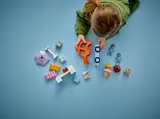 Disassembled LEGO Duplo Bluey set with hands.