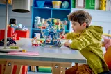 Child admiring built LEGO Ferris Wheel.