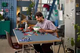 Man building LEGO Poké Ball.