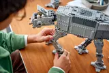 Builder adjusting LEGO AT-AT leg.