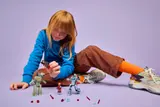 Child with all LEGO figures and accessories laid out.