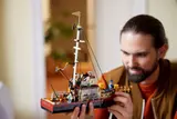 Hands holding the detailed LEGO Orca boat.