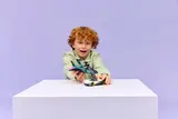 Child playing with LEGO models.
