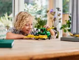 Boy playing with LEGO Technic harvester.