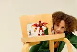 Child plays with Ninjago figures on chair.
