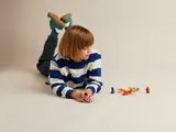 Child observes LEGO Ninjago figures arranged.