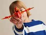 Child holds Kai and dragon in play.
