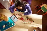 Child building LEGO Kakamora with tablet.