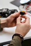 Close-up of hands building a LEGO wheel.