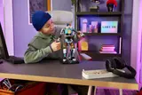 Kid holding finished Kit mech.