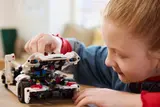 Child inspecting Technic Jesko engine.