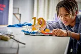 Person building LEGO Mbappé set with focus.