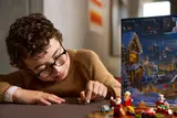 Child examining LEGO reindeer minifigure.