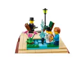 Close-up of LEGO storybook pond with swan, fountain, and minifigures.