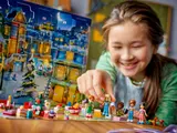 Child placing LEGO Friends minifigures.