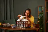 Person adding roof to LEGO house.