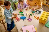 Family building LEGO on table.