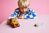 Child playing with truck and shark.