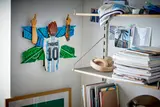 LEGO Messi model on wall with shelves.