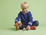 Boy playing with LEGO T. rex.
