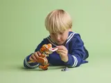 Boy feeding LEGO T. rex.