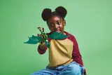 Child examines dragon model.
