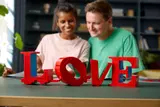 Couple admiring LEGO LOVE sculpture.