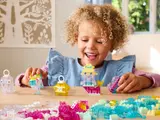 Child smiling with transparent LEGO builds.