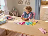 Child building with transparent LEGO bricks.