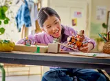 Child playing with LEGO Donkey Kong kart on a ramp.