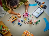 Child building LEGO Mario Kart with tablet.