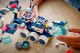 Hands discovering crystal with LEGO Mars Rover.