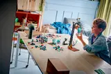 Boy playing with LEGO Mars Mission set on a table.