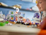 Girl playing with LEGO Mars base and rover.